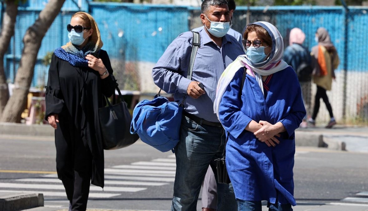 أشخاص يمشون في أحد الشوارع في طهران (12 نيسان 2021، ا ف ب). 