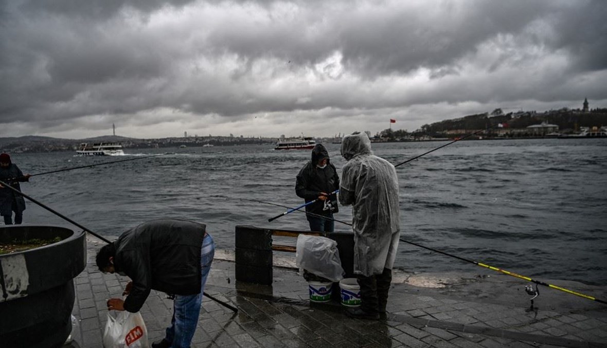 أشخاص يصطادون قرب مضيق البوسفور في أسطنبول في 8 نيسان الجاري.(أ ف ب)