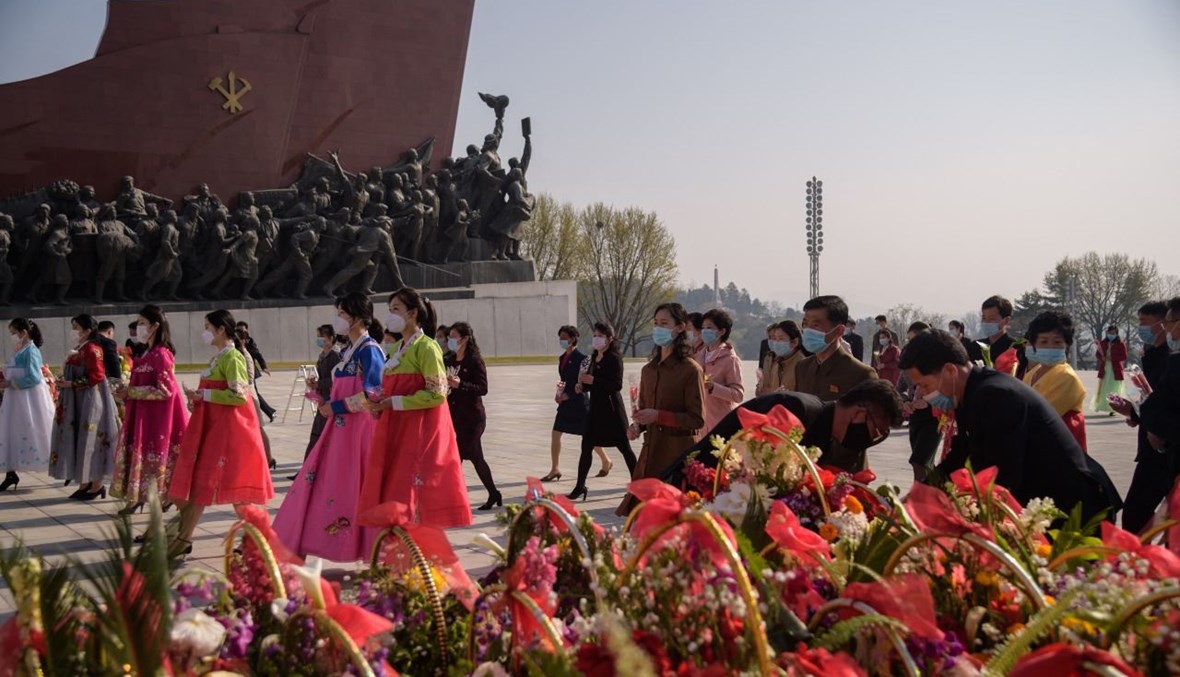 أشخاص يضعون الزهور عند تمثال كيم إيل سونغ في مانسو هيل في بيونغ يانغ (15 نيسان 2021، أ ف ب). 
