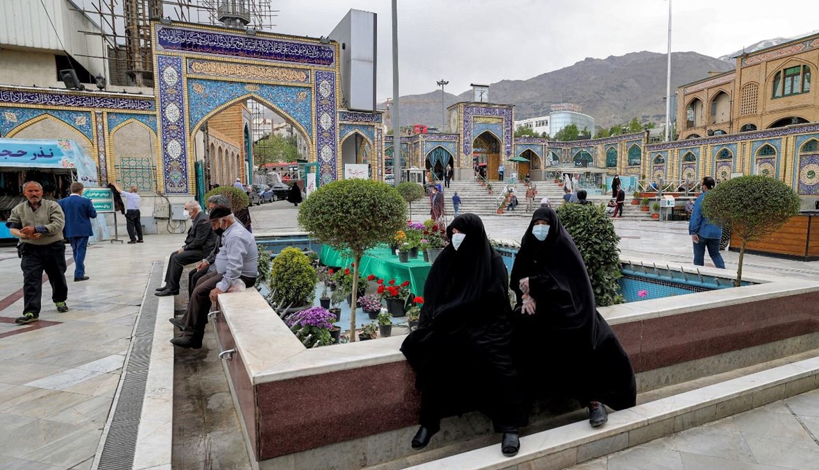 نساء جلسن في فناء ضريح إمام زاده صالح في حي شميران في طهران (14 نيسان 2021، أ ف ب). 