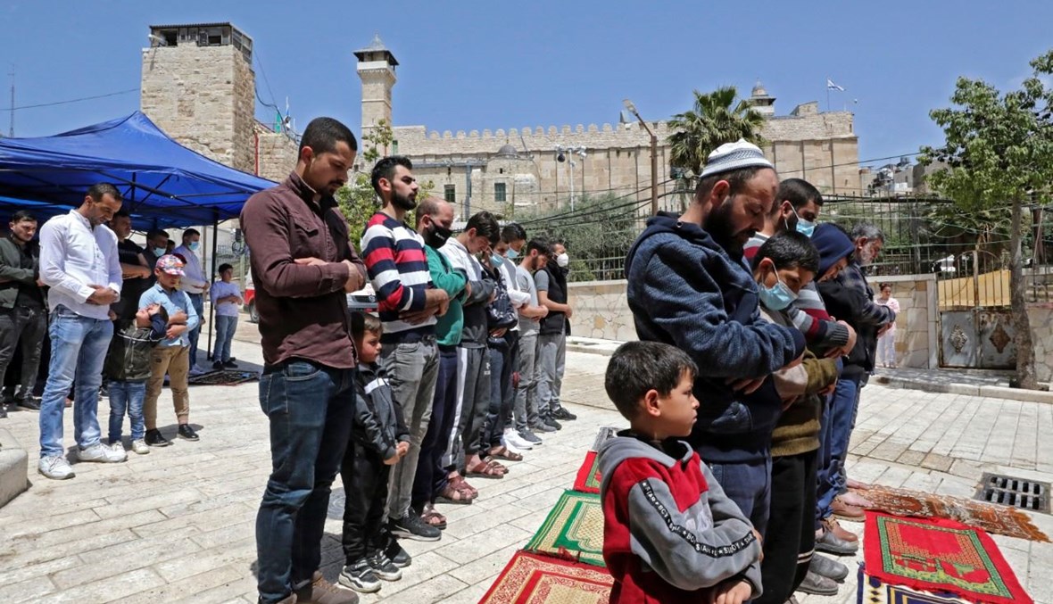 فلسطينيون يشاركون في صلاة الجمعة الأولى من شهر رمضان خارج الحرم الإبراهيمي في مدينة الخليل بالضفة الغربية المحتلة (16 نيسان 2021، أ ف ب). 