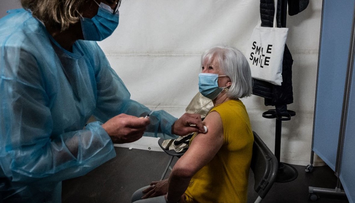 امرأة تتلقى لقاح كورونا في قصر الرياضة دي غيرلان الذي تم تحويله مركزا للتطعيم في مدينة ليون بفرنسا (23 نيسان 2021، أ ف ب).