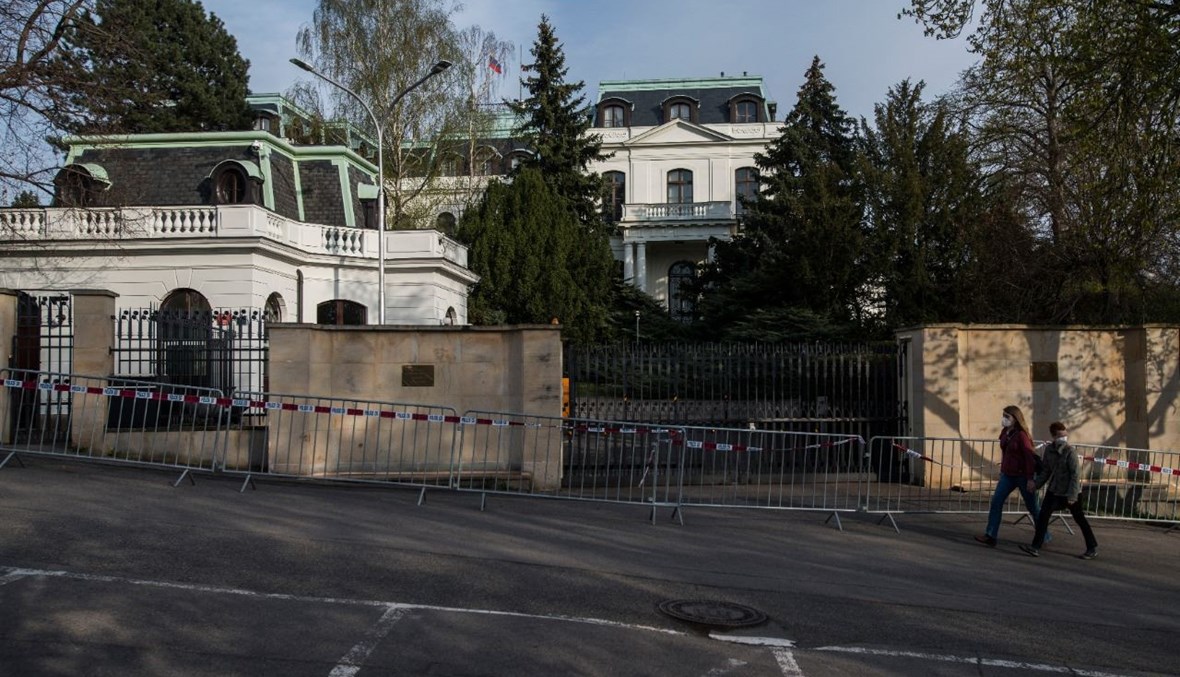 أشخاص يمرون بالقرب من السفارة الروسية في براغ (22 نيسان 2021، أ ف ب). 