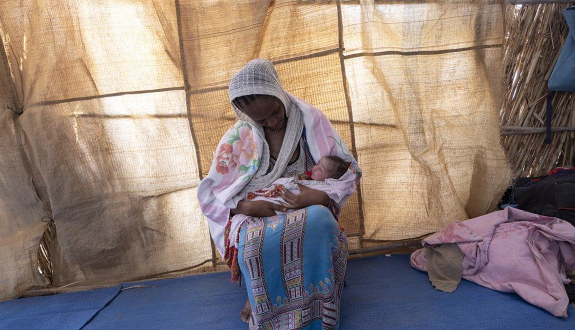 ليملم غبريهيوت، وهي لاجئة من تيغراي، تحمل رضيعتها في مأوى في حمداييت شرق السودان  (16 آذار ، ا ب). 