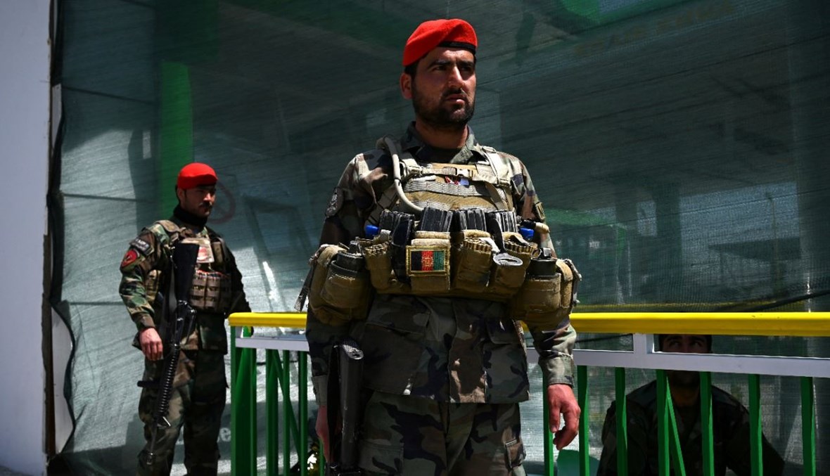 جنديان افغانيان وقفا بالقرب من محطة بنزين تضررت من جراء هجوم بقنبلة في كابول (21 نيسان 2021، أ ف ب). 