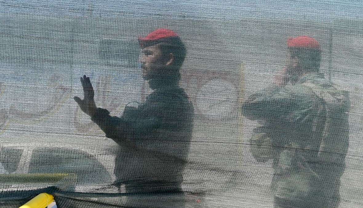 جنود أفغان يقفون بالقرب من موقع هجوم بقنبلة في كابول (21 نيسان 2021، أ ف ب). 