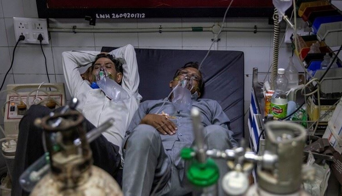 مصابان بكورونا يتشاركان سريراً واحداً في أحد مستشفيات نيودلهي.