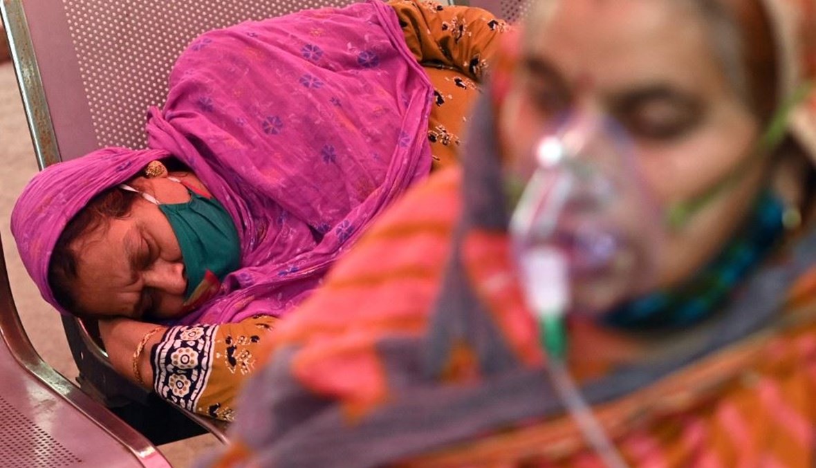 مريضة تستلقي على مقعد في انتظار حصولها على أوكسجين بمعبد في مدينة غازي آباد الهندية أمس.(أ ف ب)