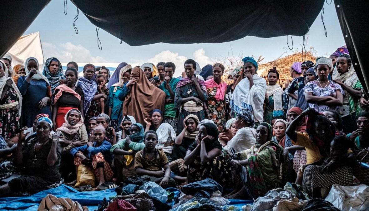 نازحون فارون من العنف في منطقة ميتيكل غرب إثيوبيا، تجمعوا امام خيمة في مخيم في تشاغني بإثيوبيا (26 ك2 2021، أ ف ب). 