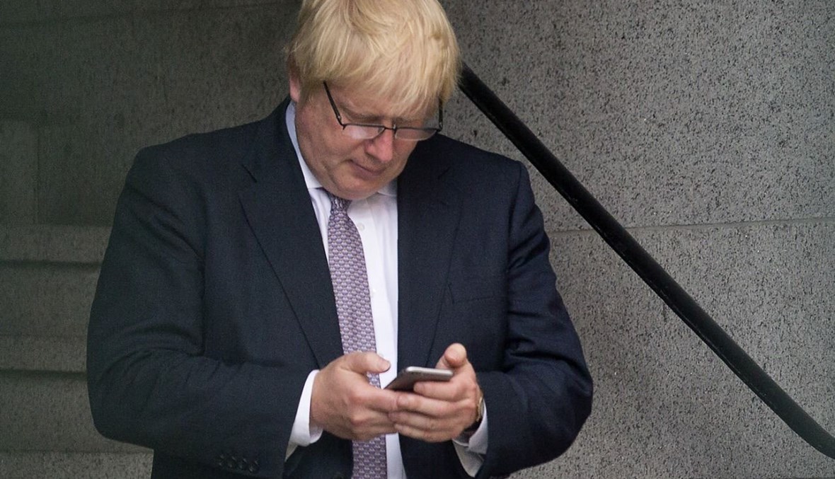جونسون يستخدم هاتفًا محمولًا داخل مبنى مجلس البرلمان وسط لندن (27 حزيران 2016، أ ف ب). 