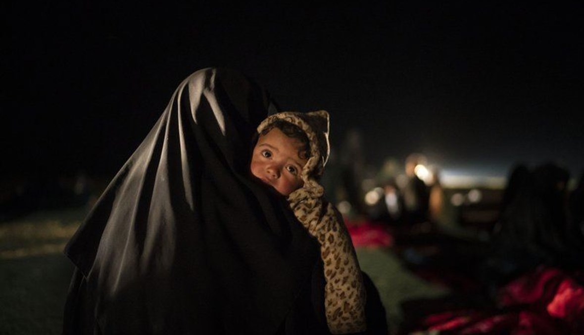 امرأة تحمل طفلها في مركز تديره قوات سوريا الديموقراطية خارج الباغوز بسوريا (25 شباط 2019، أ ب). 