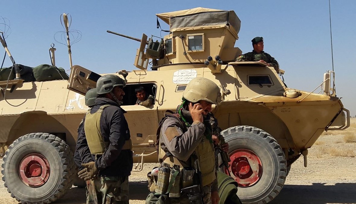 قوات أمن أفغانية تقف بالقرب من مدرعة خلال قتال مع مقاتلي طالبان في منطقة بوشاران بضواحي لشكركاه عاصمة ولاية هلمند (5 ايار 2021، أ ف ب). 