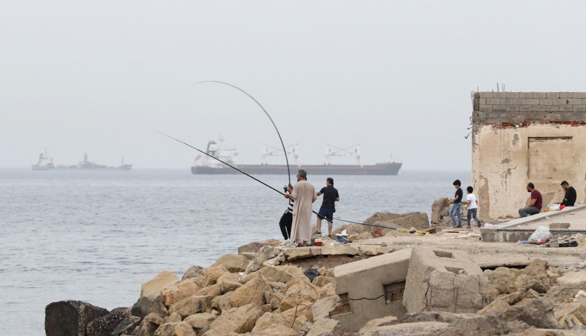 ليبيون يصطادون عند شاطئ في طرابلس (30 نيسان 2021، أ ف ب). 