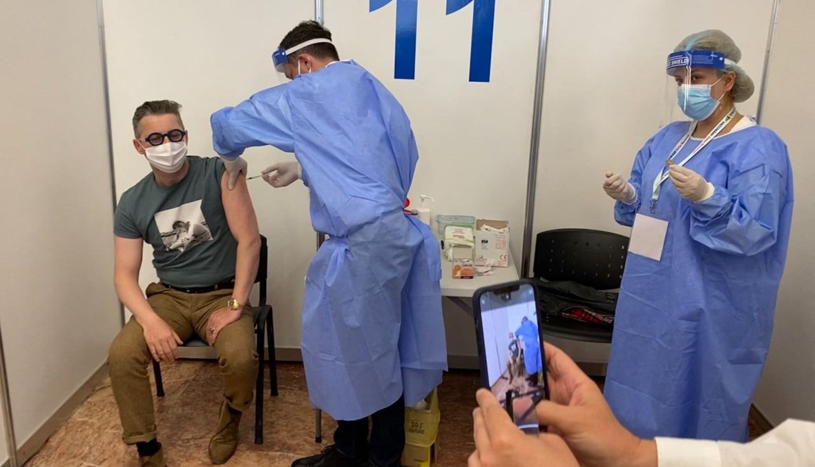 رجل يتلقى لقاح كورونا في مركز تطعيم في بوخارست برومانيا (7 ايار 2021، أ ف ب). 
