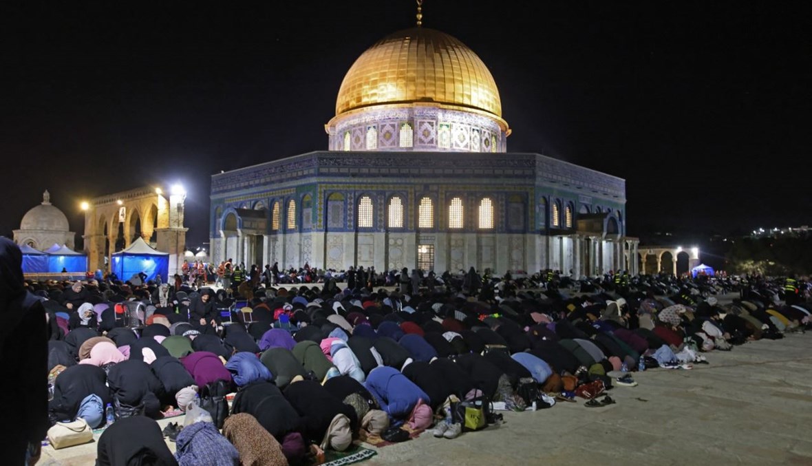 فلسطينيون يصلون في ليلة القدر خارج قبة الصخرة في مجمع المسجد الأقصى بالقدس (8 ايار 2021، أ ف ب). 