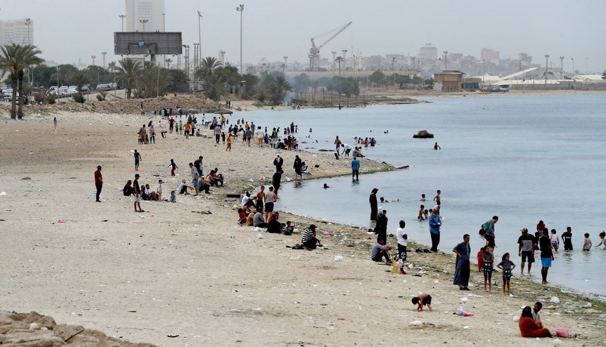 ليبيون تجمعوا على شاطئ في العاصمة طرابلس (30 نيسان 2021، أ ف ب). 