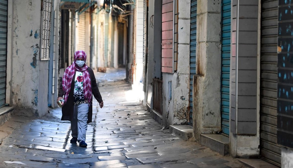 امرأة تمشي في سوق مغلقة في تونس (9 ايار 2021، أ ف ب). 