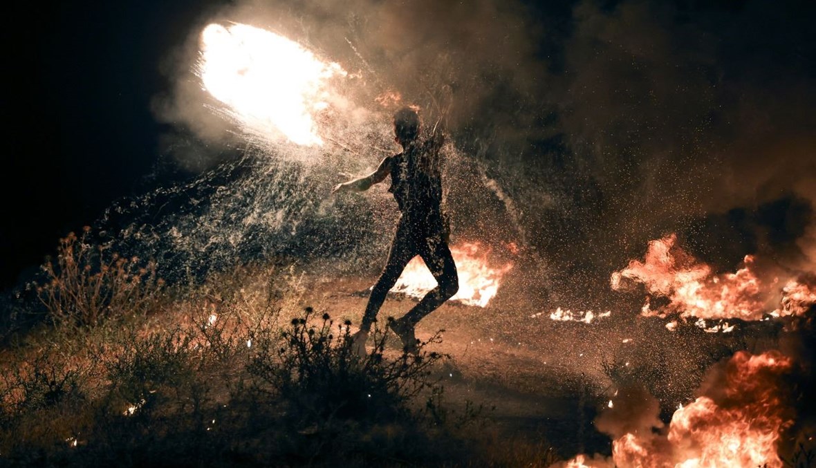 فلسطيني يحرق الإطارات خلال تظاهرة على طول الحدود بين إسرائيل وغزة شرق مدينة غزة (8 ايار 2021، أ ف ب). 