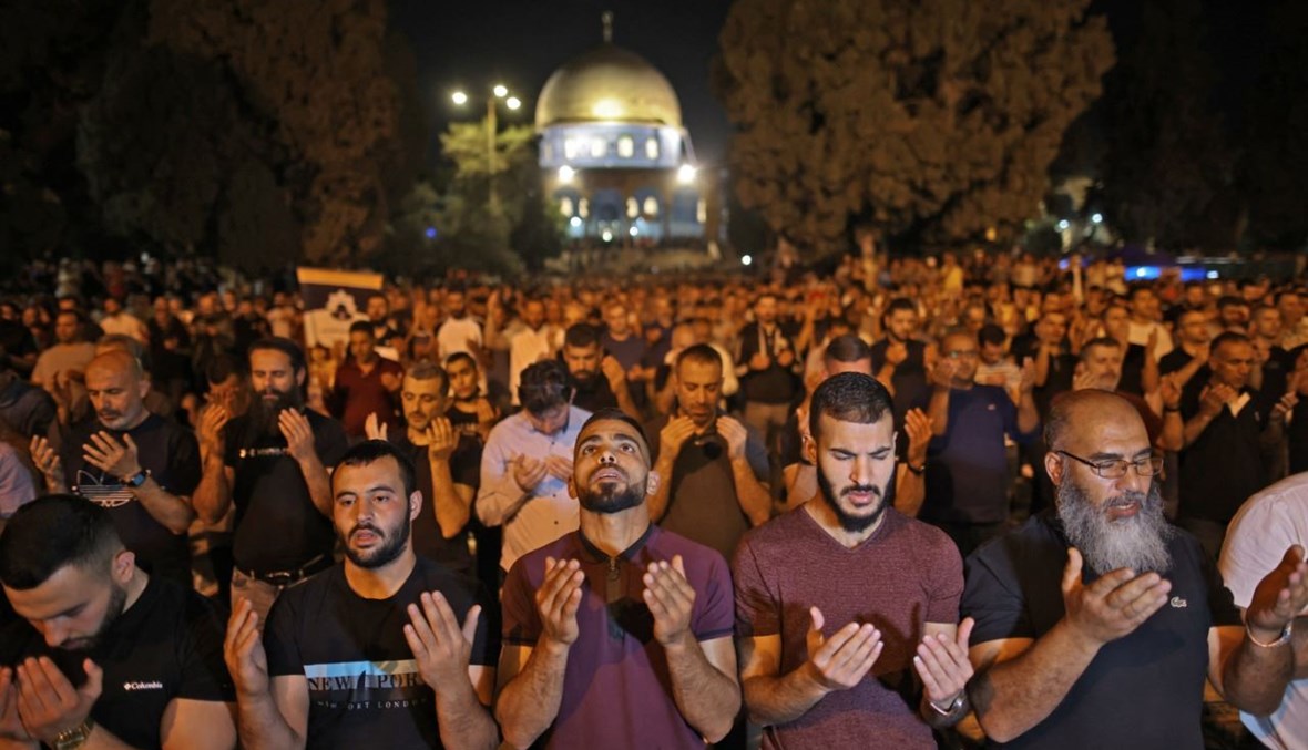 فلسطينيون يصلون في ليلة القدر خارج قبة الصخرة في مجمع المسجد الأقصى بالقدس (8 ايار 2021، أ ف ب). 