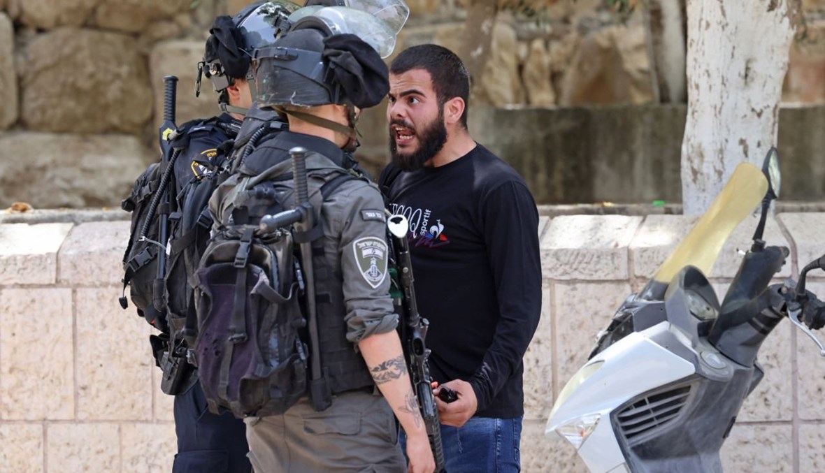 متظاهر فلسطيني يتجادل مع قوات الأمن الإسرائيلية في البلدة القديمة بالقدس (10 ايار 2021، أ ف ب).  