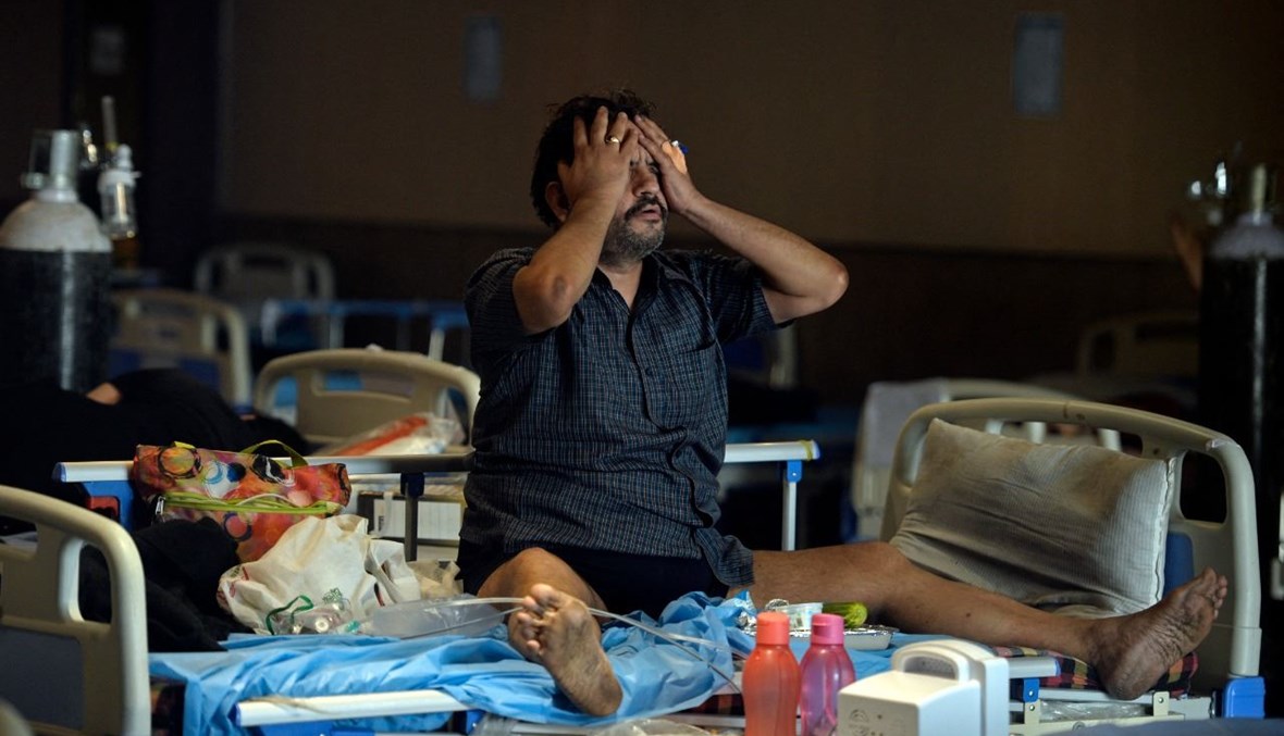 رجل مصاب بكورونا يستريح داخل قاعة تم تحويلها مركزا موقتا لعلاج المصابين في نيودلهي (10 ايار 2021، أ ف ب). 