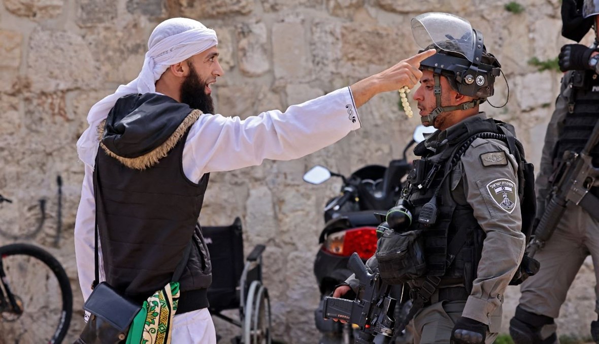 متظاهر فلسطيني يتجادل مع عنصر من قوات الأمن الإسرائيلية في البلدة القديمة بالقدس (10 ايار 2021، أ ف ب).  