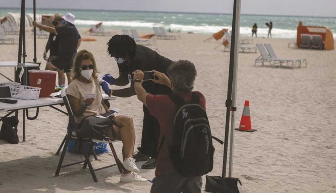 سياح من أميركا اللاتينية على شواطئ ميامي يتلقون اللقاح. (أ ف ب)