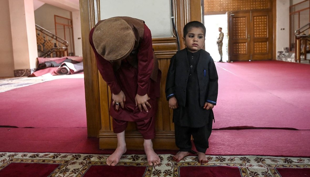 رجل وطفل يؤديان صلاة عيد الفطر في مسجد عبد الرحمن في كابول (13 ايار 2021، أ ف ب). 