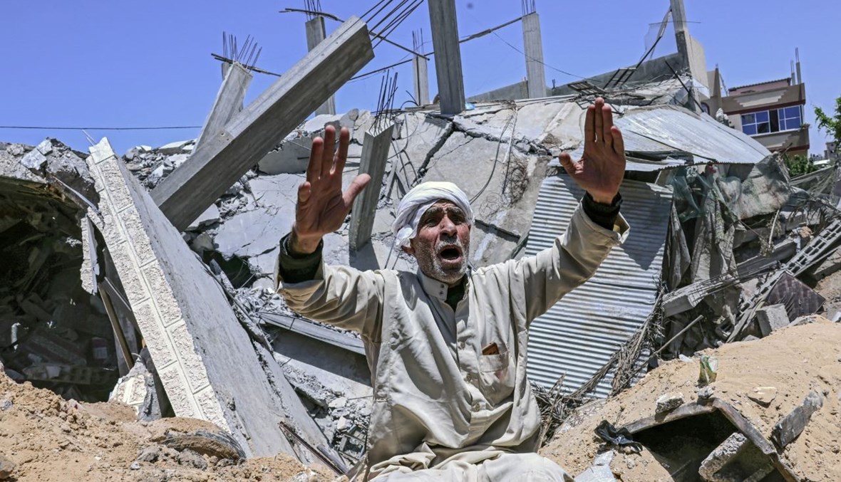 فلسطيني يجلس وسط أنقاض منزله بعدما دمرته غارة جوية إسرائيلية في مدينة رفح جنوب قطاع غزة (16 ايار 2021، ا ف ب). 