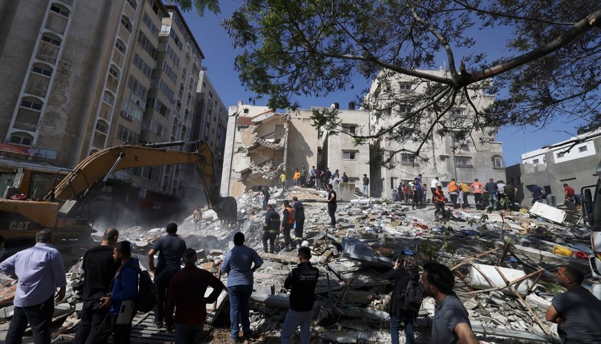 فرق إنقاذ فلسطينية تبحث عن ناجين تحت أنقاض مبنى مدمر في حي الرمال السكني في مدينة غزة (16 ايار 2021، أ ف ب). 
