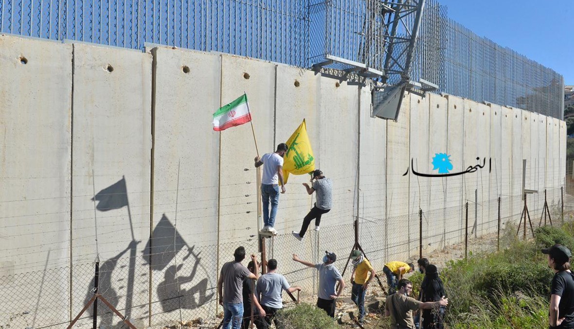 متظاهرون يتسلّقون جدار الإسمنت الفاصل بين لبنان والحدود الفلسطينية في كفركلا لتثبيت علَمي "حزب الله" وفلسطين (نبيل اسماعيل).