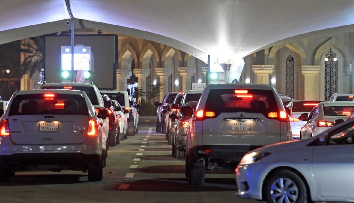 سعوديون بسياراتهم عند نقطة العبور إلى البحرين عبر جسر الملك فهد ليل الاحد. (أ ف ب)