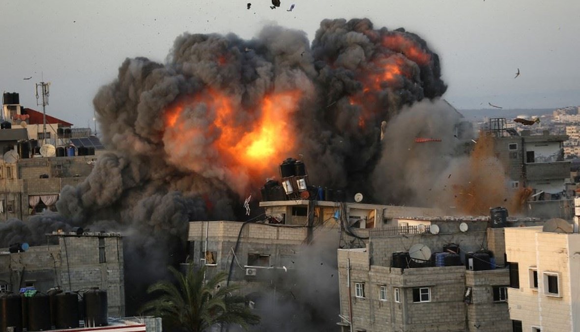 كتل من النار والدخان تتصاعد من مبانٍ استهدفها القصف الإسرائيلي في حي الرمال السكني بمدينة غزة ليل الأحد.   (أ ف ب)