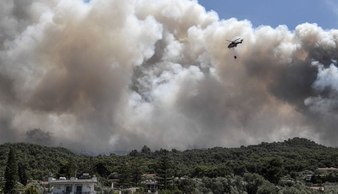 مروحية إطفاء تحلق فوق قرية اليبوشور خلال مكافحة حريق اندلع بسلسلة جبلية تطل على خليج كورينثوس (20 ايار 2021، أ ف ب). 