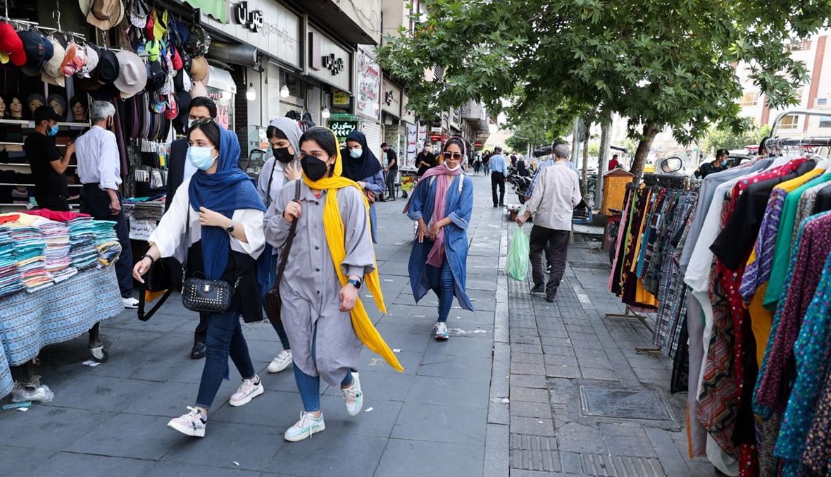 نساء إيرانيات يمرن امام متاجر في ساحة إنغلاب في وسط طهران (16 ايار 2021، أ ف ب). 