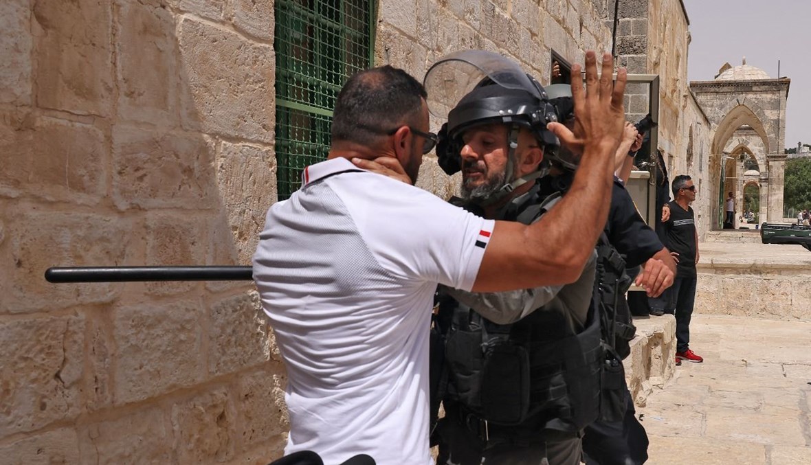 فلسطيني خلال مواجهة مع عنصر من القوات الامن الاسرائيلية في المسجد الأقصى بالقدس (21 ايار 2021، أ ف ب). 