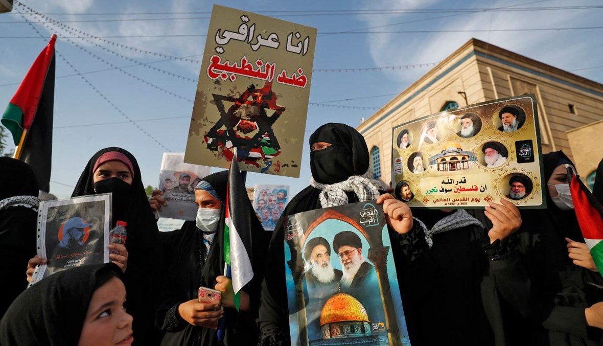 أنصار لقوات الحشد الشعبي يحملون لافتات خلال تظاهرة في العاصمة بغداد دعما للفلسطينيين (20 ايار 2021، أ ف ب). 