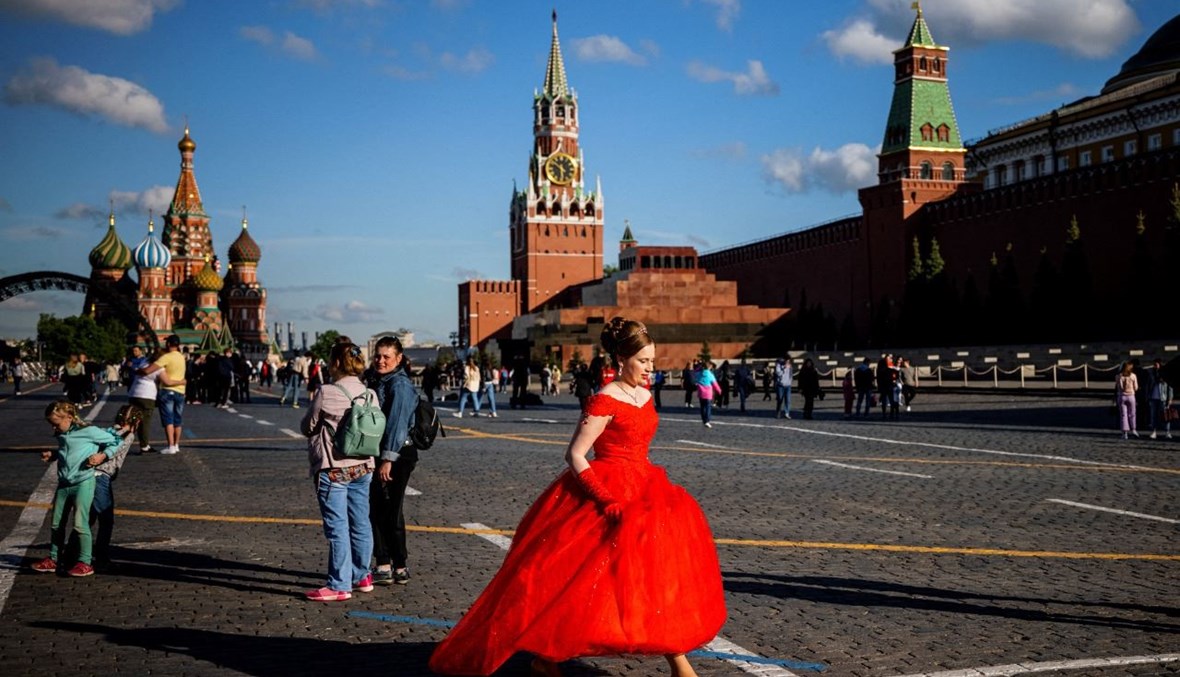 امرأة بفستان أحمر تمشي في الساحة الحمراء في موسكو (21 ايار 2021، أ ف ب). 