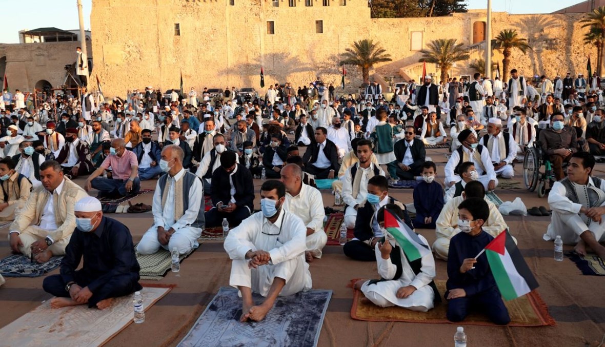 ليبيون مسلمون تجمعوا في ساحة الشهداء بالعاصمة طرابلس لأداء صلاة عيد الفطر (13 ايار 2021، أ ف ب). 