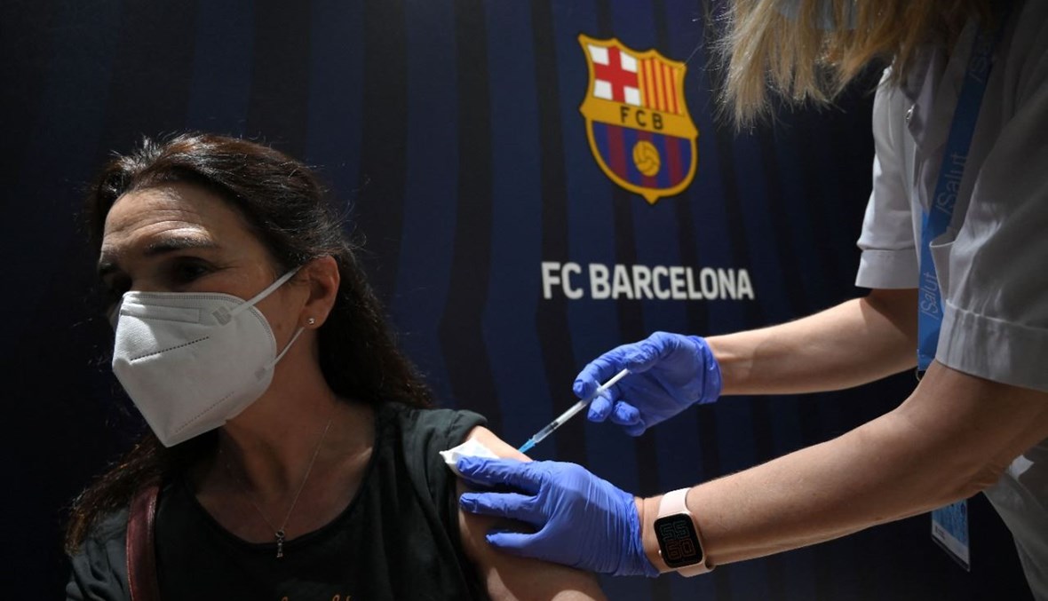 امرأة تتلقى لقاح فايزر/بايونتيك في ملعب كامب نو في برشلونة (27 ايار 2021، أ ف ب). 