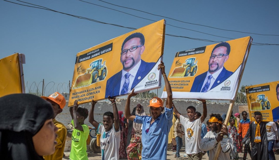 أشخاص يرفعون صور مرشحين لانتخابات أرض الصومال خلال تجمع لحزب "وداني" المعارض في هرجيسا، عاصمة أرض الصومال (25 ايار 2021، أ ف ب). 