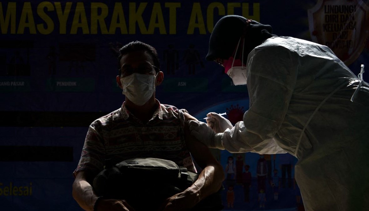 موظف حكومي يتلقى لقاح كورونا خلال تطعيم جماعي في مكتب المحافظ في باندا آتشيه بإندونيسيا (3 حزيران 2021، أ ف ب). 