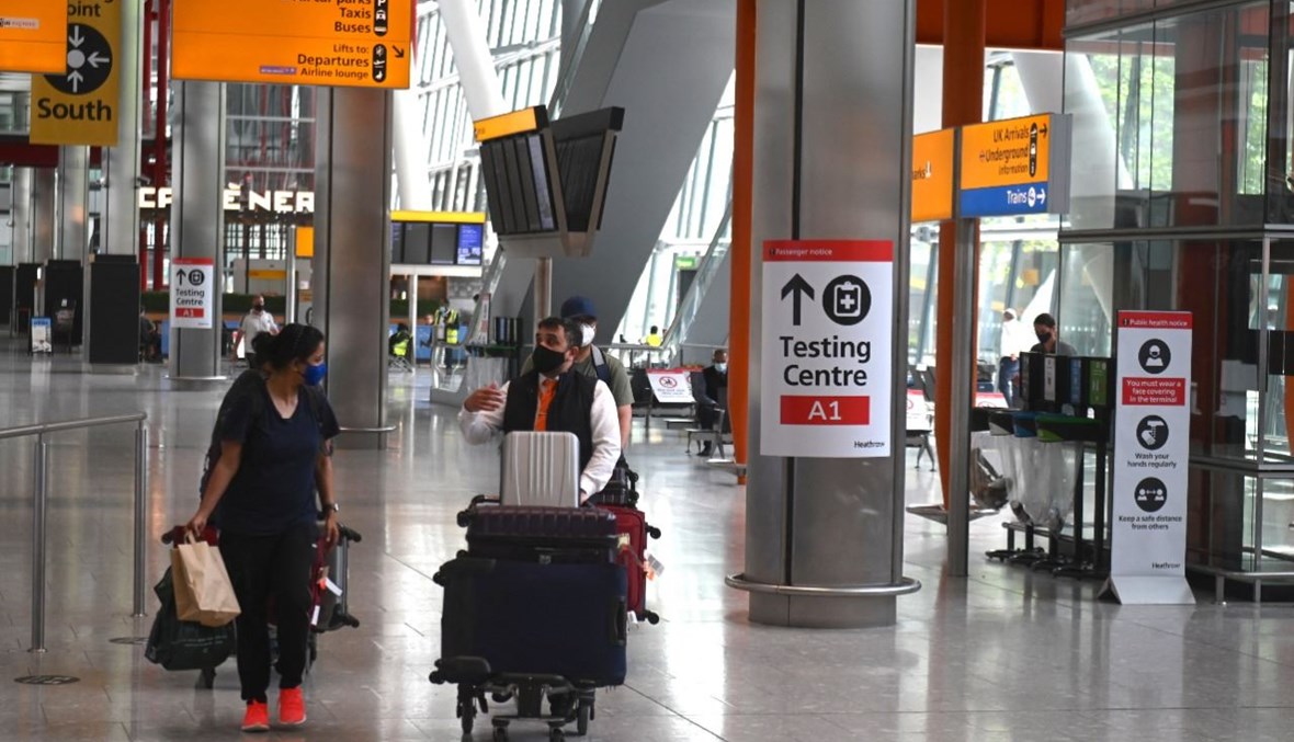 مسافرون يدفعون أمتعتهم في مطار هيثرو بلندن (3 حزيران 2021، ا ف ب). 