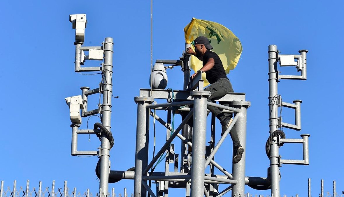 مناصر لـ"حزب الله" يتسلّق برج كاميرات المراقبة عند الحدود اللبنانية الجنوبية (حسام شبارو).