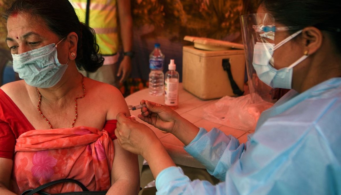 امرأة تتلقى لقاح كورونا في كاتماندو (10 حزيران 2021، أ ف ب). 