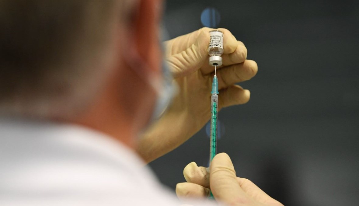 عامل طبي يجهز حقنة بلقاح كورونا في مركز تطعيم تابع لشركة ترامف في ديتزينجين بجنوب ألمانيا (10 ايار 2021، أ ف ب). 