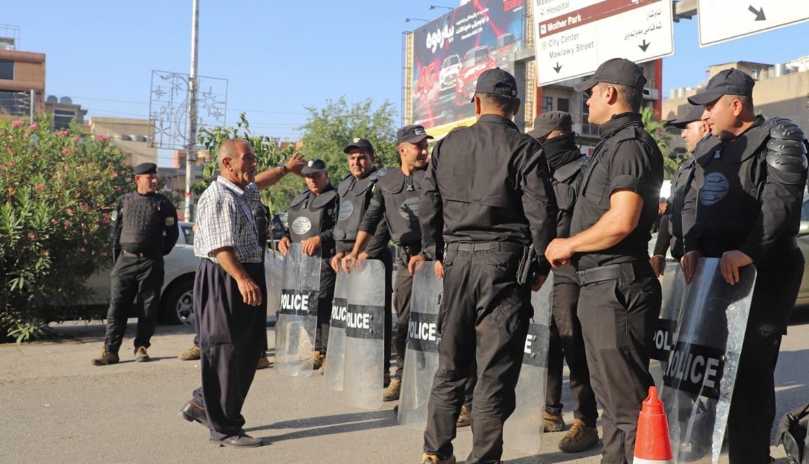 عناصر من الشرطة العراقية يقفلون طريقًا، بينما يتظاهر أكراد العراق في مدينة السليمانية احتجاجًا على الهجوم التركي في شمال العراق (5 حزيران 2021، أ ف ب).