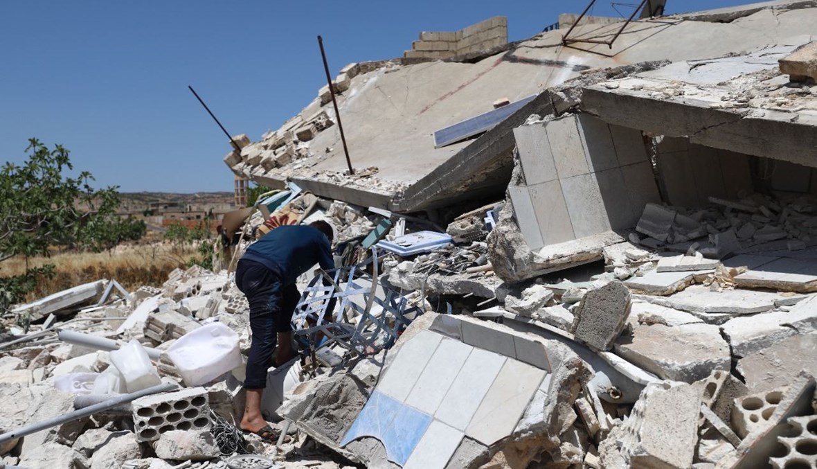 رجل يبحث بين أنقاض منزل مدمر في قرية إبلين بمحافظة إدلب شمال غرب سوريا بعد تعرضها لقصف من قوات النظام (10 حزيران 2021، أ ف ب). 