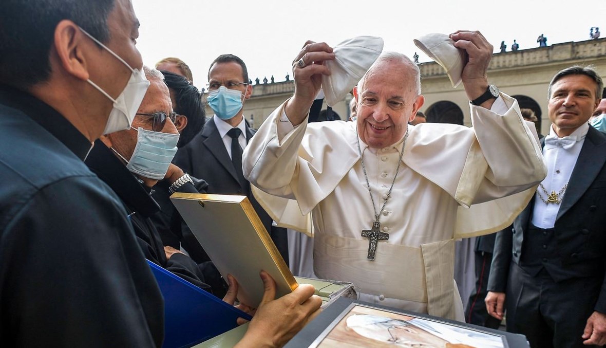 البابا فرنسيس يتلقى هدايا من اشخاص لدى وصوله الى اللقاء الاسبوعي العام في ساحة سان داماسو في الفاتيكان (9 حزيران 2021، أ ف ب). 