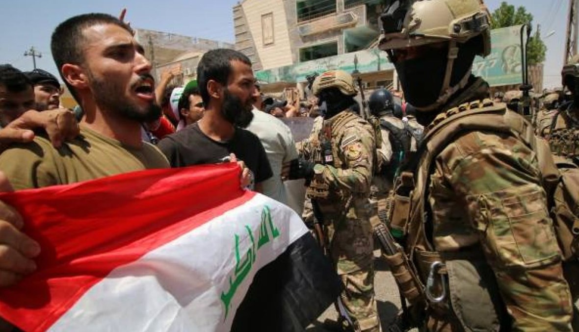 صورة لشابّ يرفع العلم العراقي